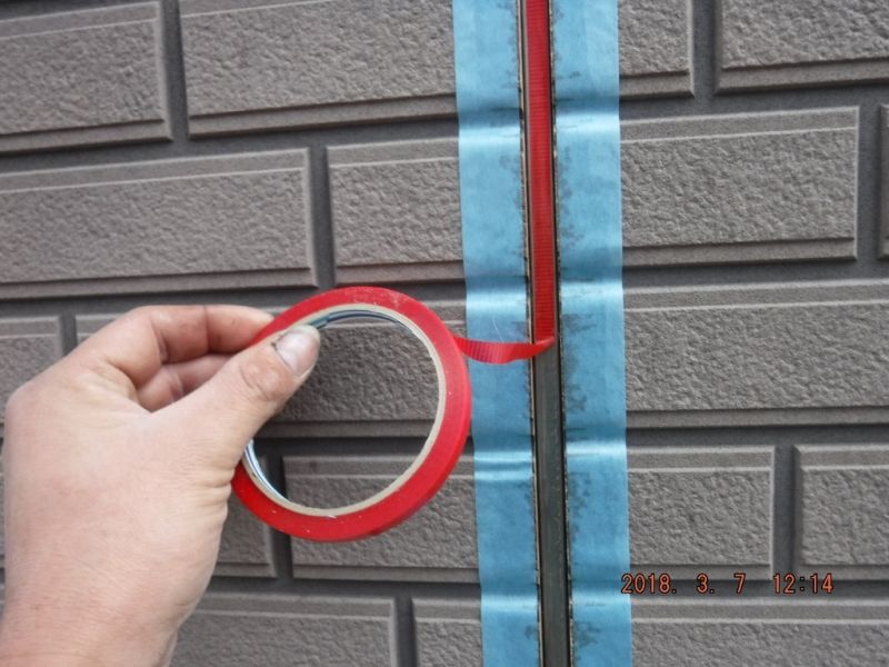 縦目地の底に赤いボンドブレーカーを貼る作業