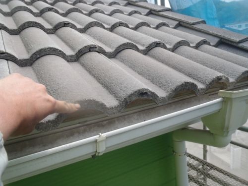 小屋根の軒先の瓦先端を指で示した様子