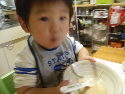食事中にラーメンの器を持つ子ども