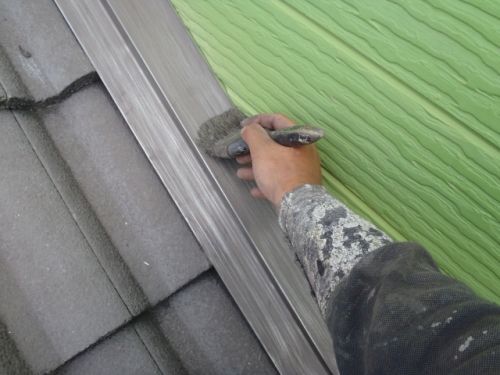 目荒し後の雨押さえ板金を刷毛で清掃