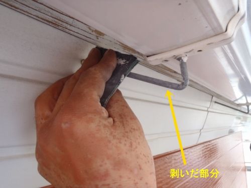 雨樋の支持金具に残る古い塗膜を削り落とす