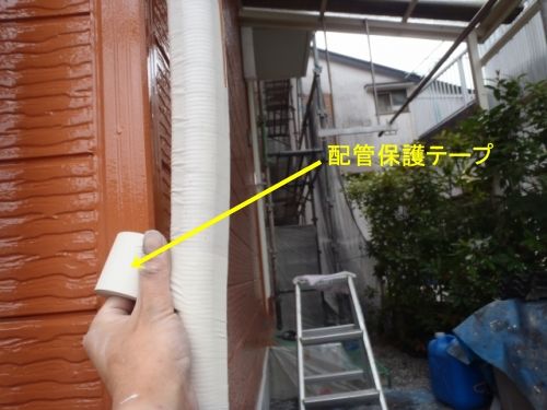北面のエアコン配管に保護テープを巻き直す作業