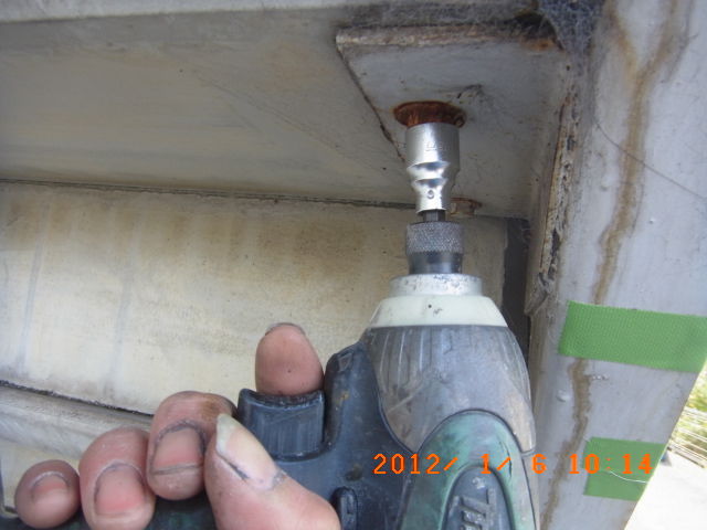 電動工具で階段裏のボルトを緩める確認作業