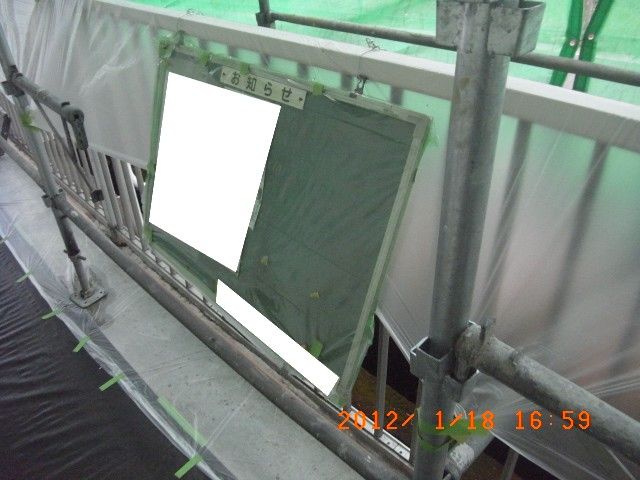 透明ビニールで養生し手すりに掛けた案内板