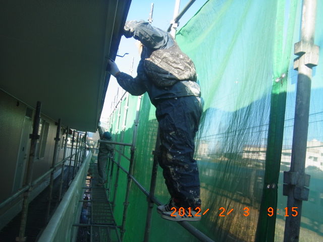 足場上で破風の目荒しを進める職人