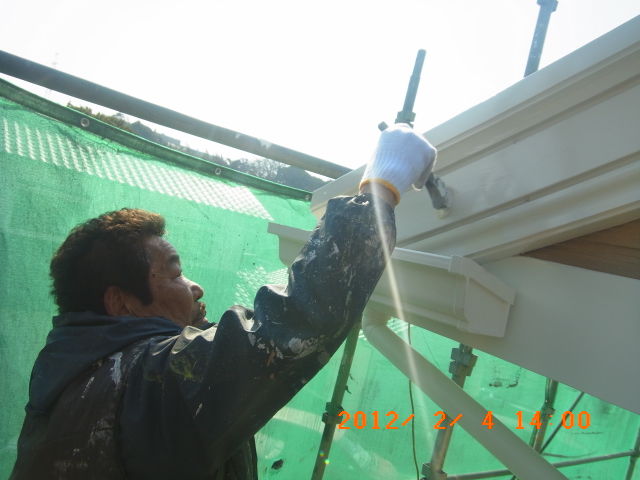 破風板を刷毛で下塗りする作業