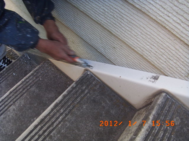 手工具で階段側板の旧塗膜を剥がす作業