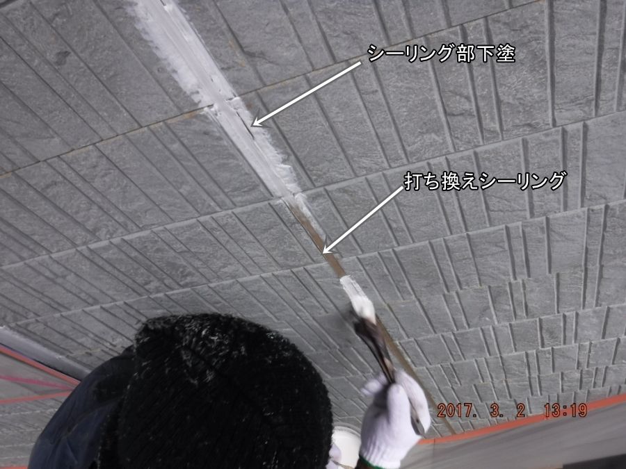 打ち替えた外壁目地のシーリング面に下塗りする作業