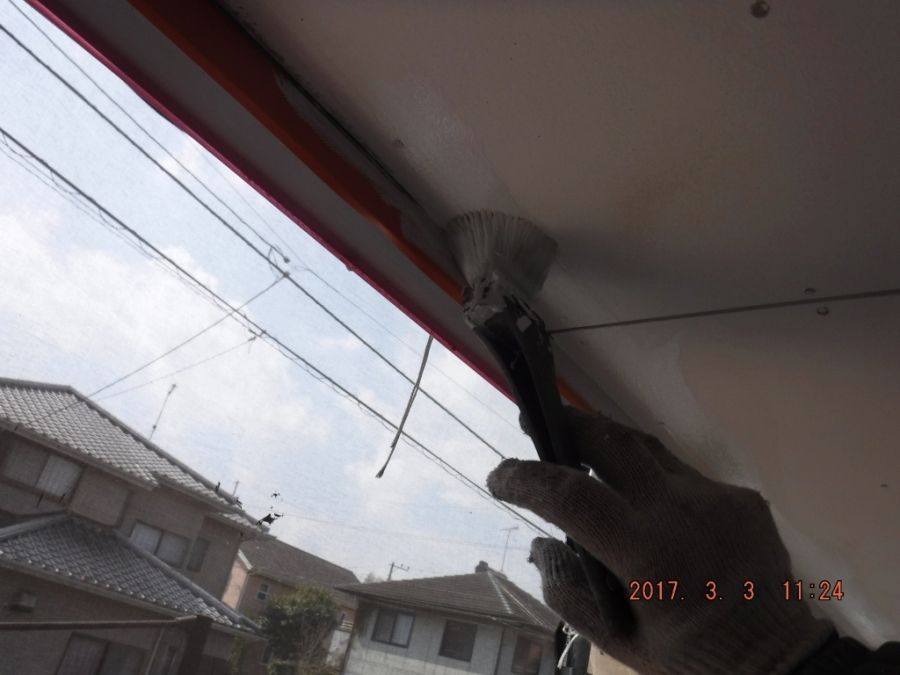 軒裏の端部を刷毛で塗装する作業