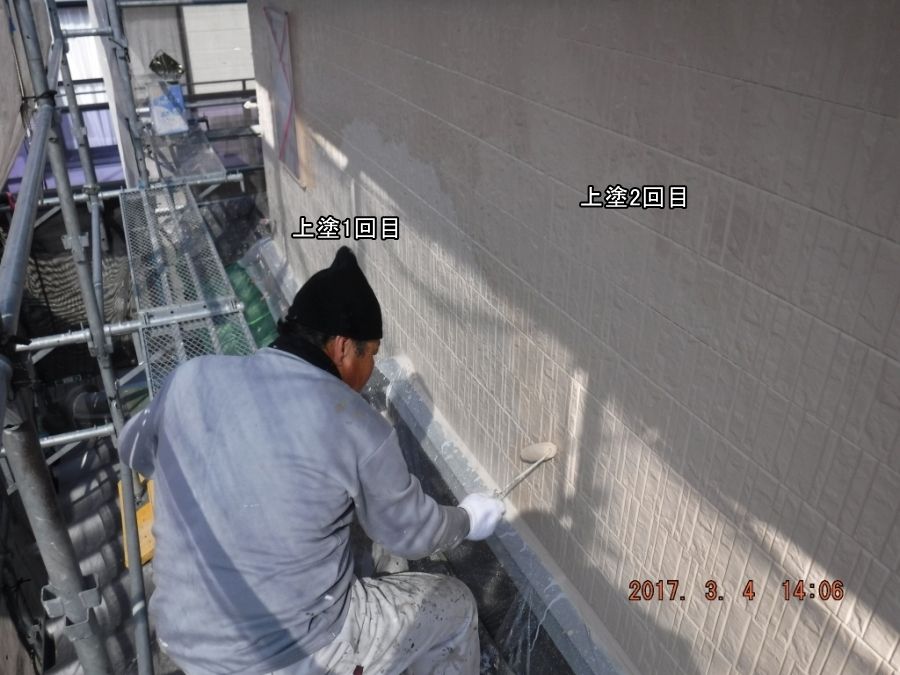 ローラーで外壁に上塗り2回目を塗る作業