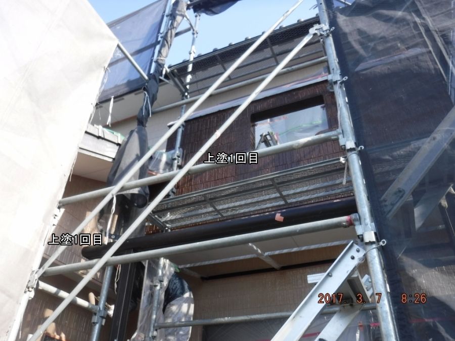 上塗り1回目を塗布した玄関周囲と右側バルコニー外壁