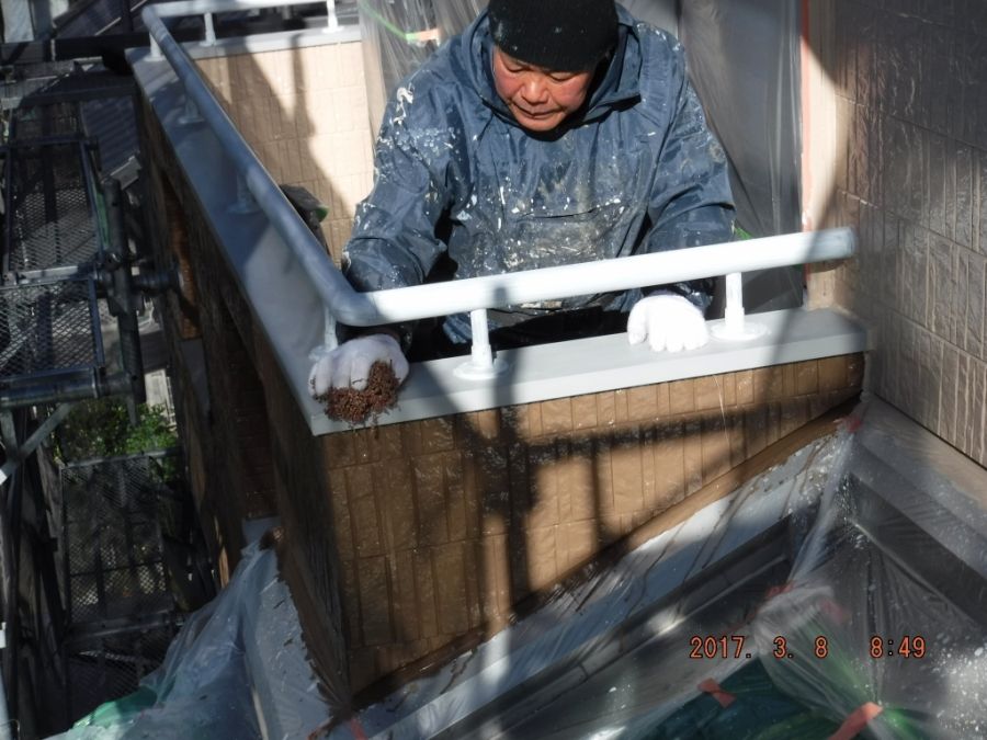 上塗り前にバルコニー笠木を研磨する作業
