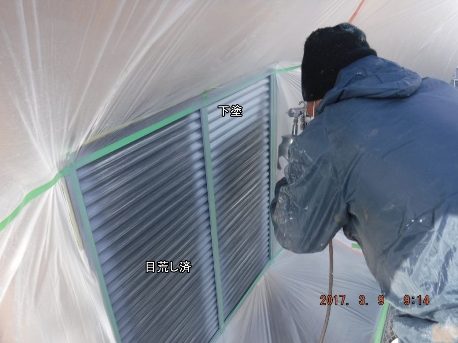 養生した戸袋に下塗剤を吹き付ける作業
