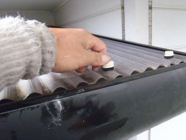 波板屋根の固定フックを外す作業