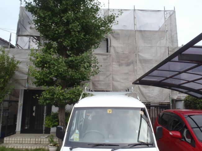 足場とメッシュシートを設置したシーリング作業日の住宅
