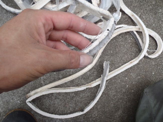 撤去した既存シーリングの厚みを手に取って確認