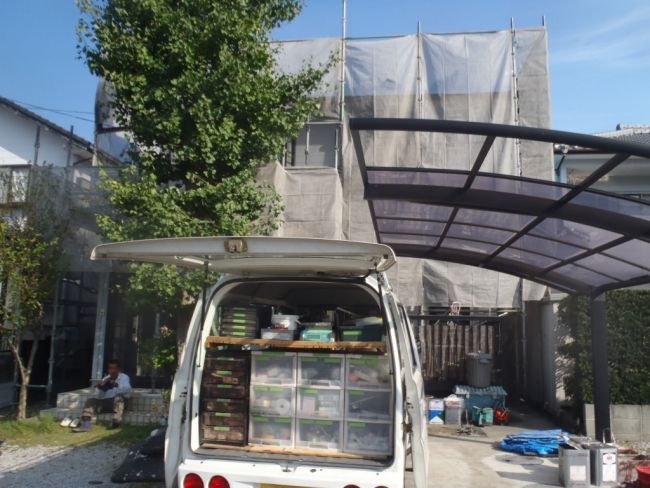 足場シートで囲まれたいし様邸と作業車
