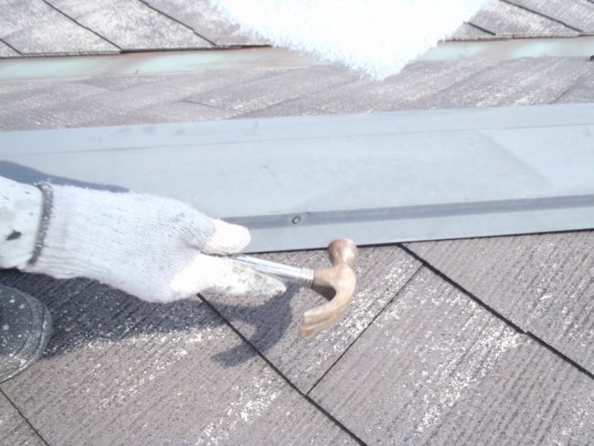 棟包み板金の浮いた釘を打ち込む作業