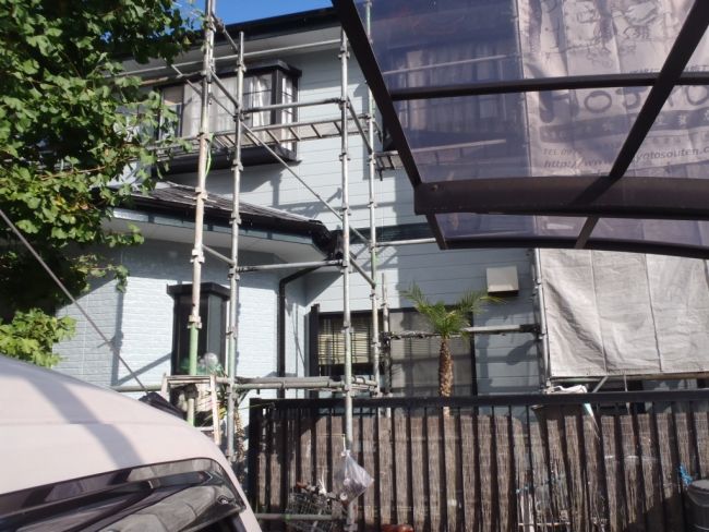 屋根の塗装作業を進める住宅外観