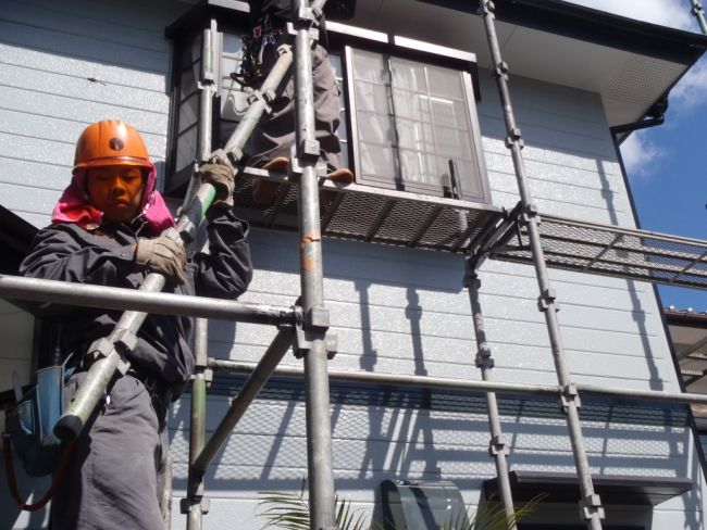 足場の部材を取り外して運ぶ作業員