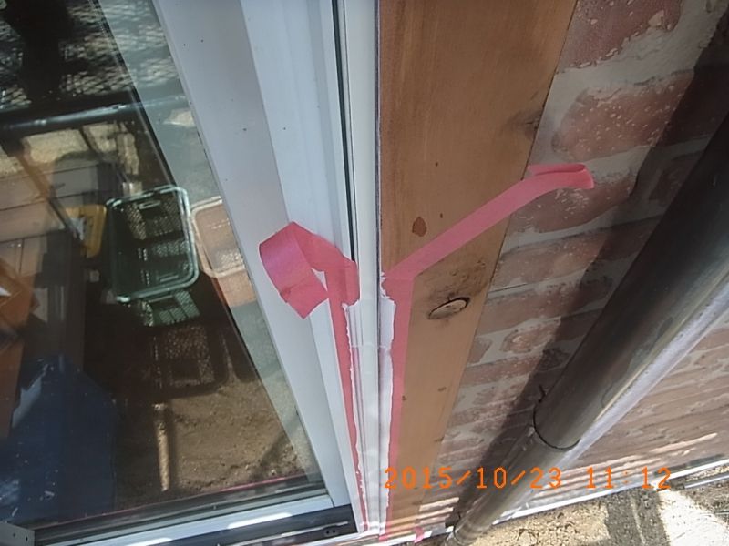 窓脇のシーリングを仕上げて養生テープを外す途中