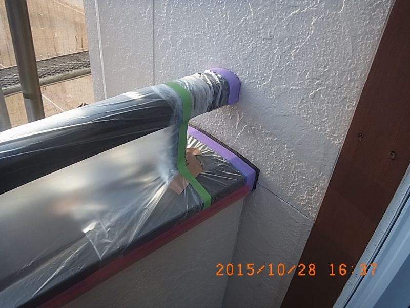手すりの壁際に紫色テープを使った養生