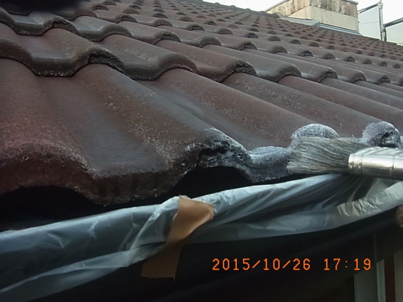 軒先の瓦の木口に下塗り材を刷毛塗り