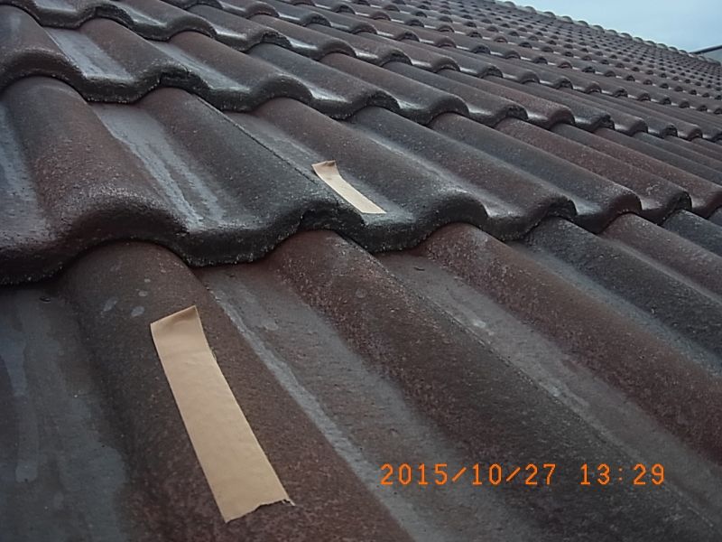 下塗り後の屋根瓦に付着確認用テープを貼る