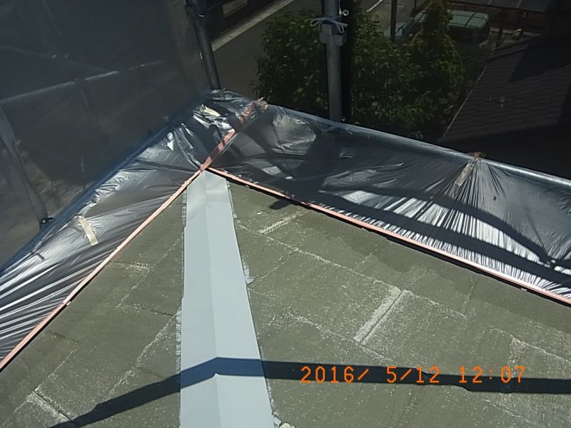 屋根の隅部を囲むビニール養生