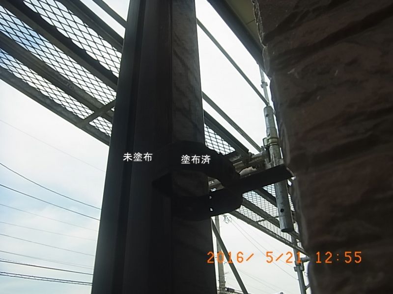 金具に固定した縦樋の塗装済み面と未塗装面