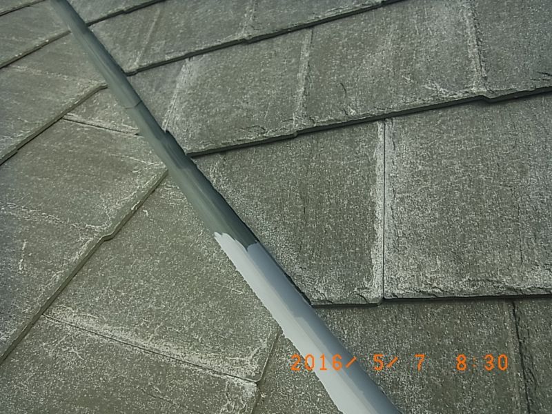屋根の谷板金に錆止めを塗布している途中