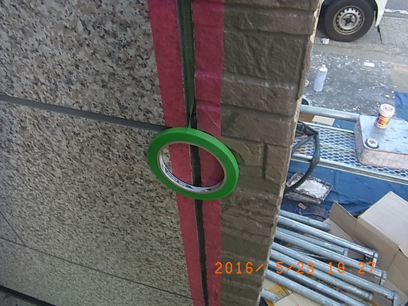 玄関脇の縦目地にボンドブレーカーを貼る作業