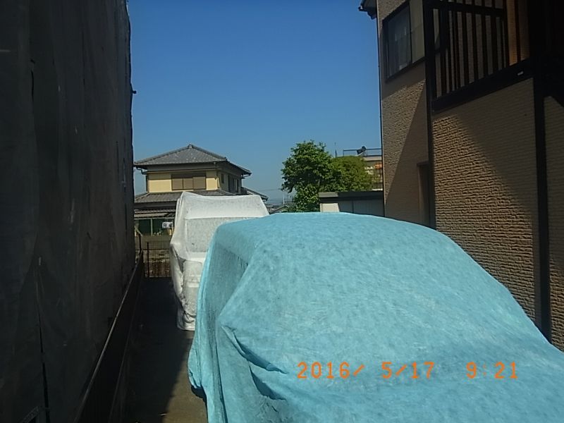 塗料の飛散を防ぐためカバーで養生した隣家の車