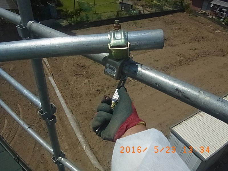 足場上段のクランプを緩める作業