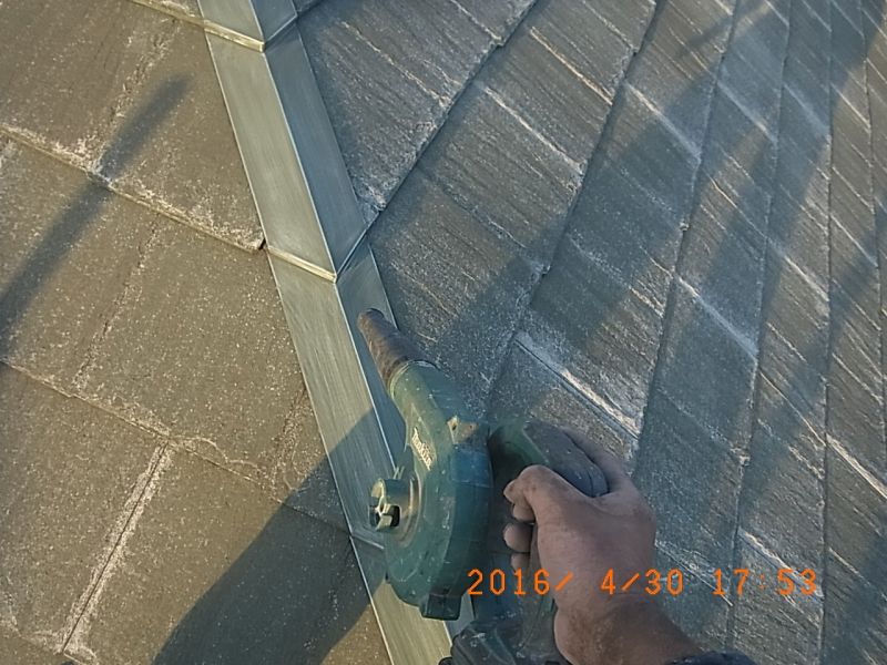屋根板金の研磨粉をブロワーで吹き払う作業