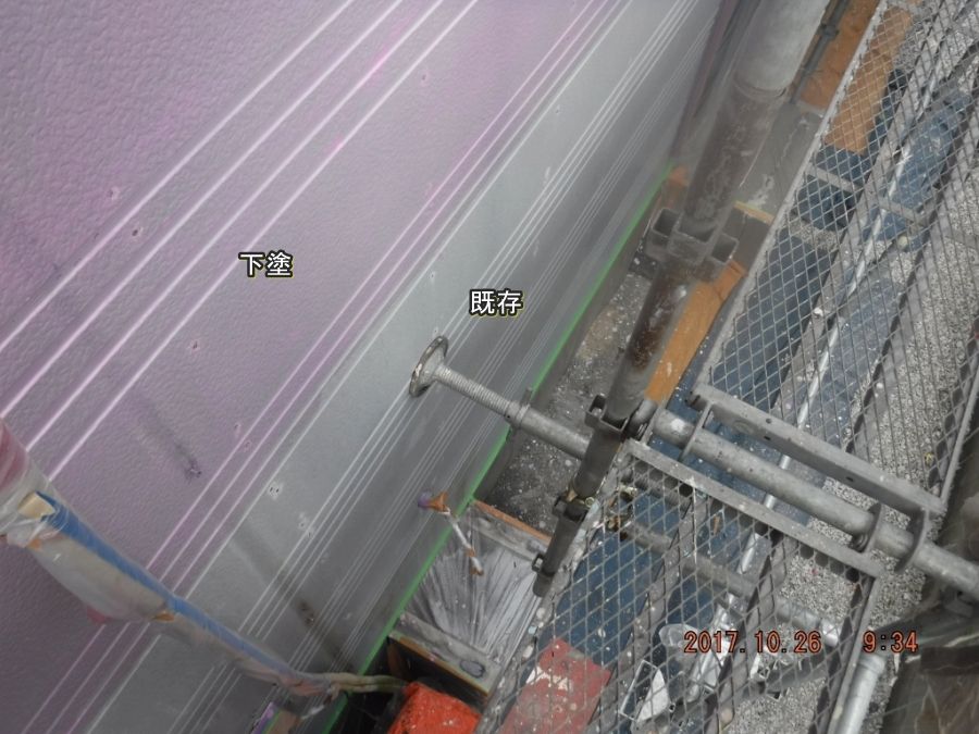 外壁下部の既存面とピンク色の下塗り部分
