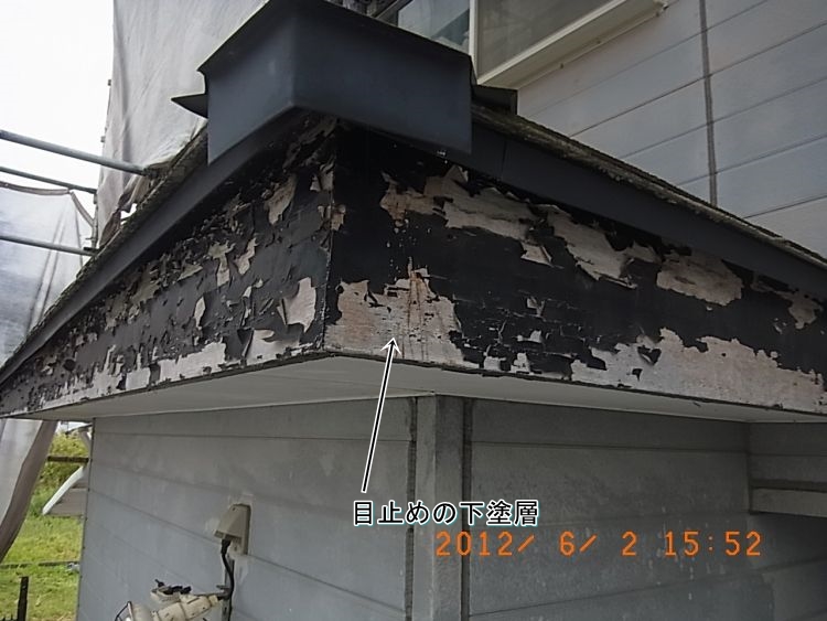 塗膜が剥がれ、白い目止め下塗り層が露出した木部