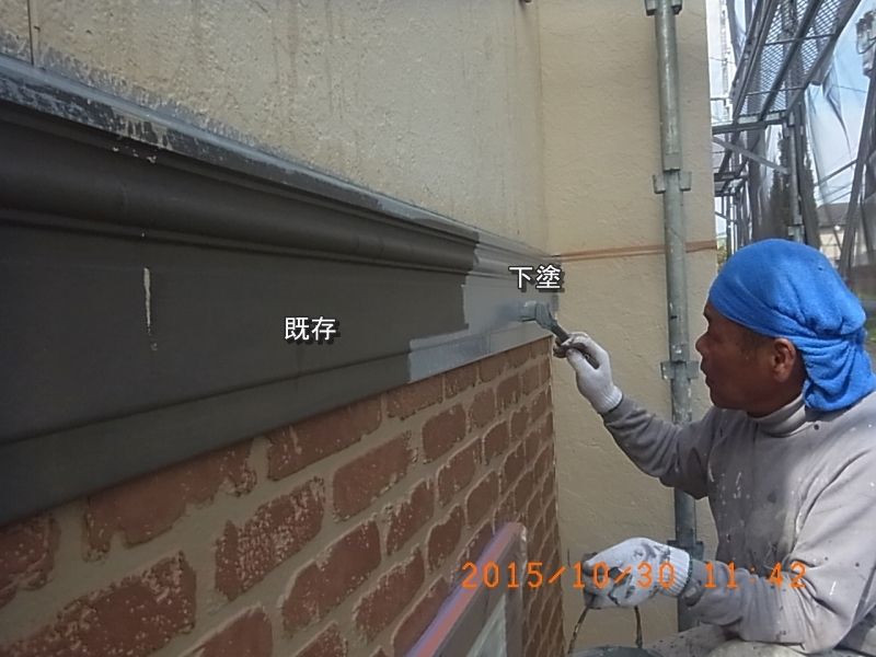 外壁の幕板を刷毛で下塗りする職人