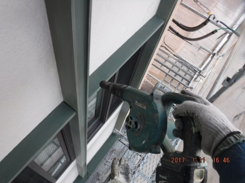 ブロワーで飾り枠の研磨粉を吹き飛ばす作業