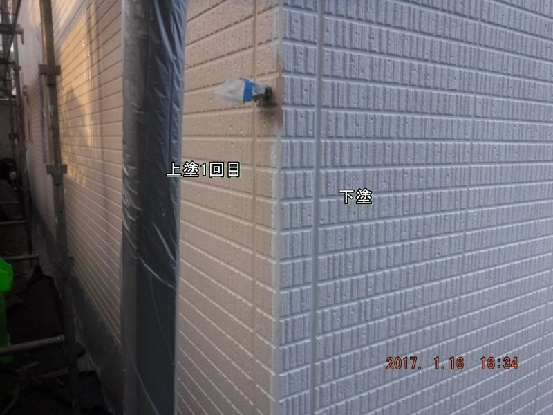 外壁出隅の上塗り1回目と白い下塗り面