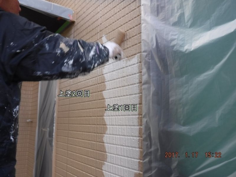 窓際の外壁にローラーで上塗り2回目を塗る作業