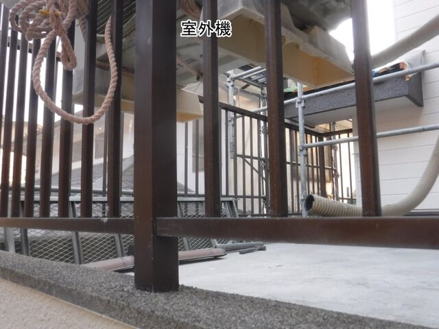 バルコニーの手すりと上方に吊り上げた室外機