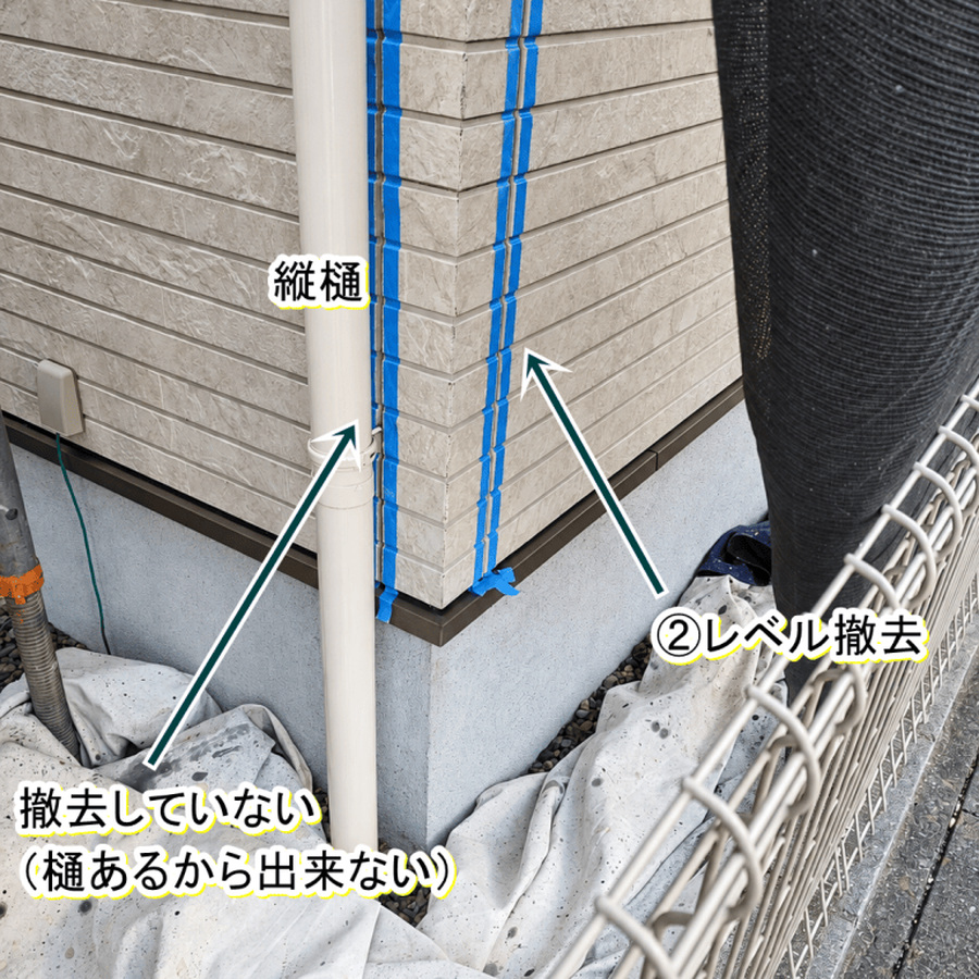 縦樋の裏に未撤去のシーリングが残る外壁目地と、右側の撤去済み目地
